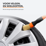 Stevige detailkwast reinigt de openingen van een wieldop van camper of caravan
