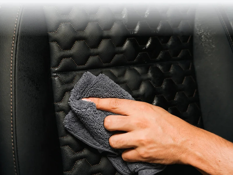Grijze Carmotec microvezeldoek neemt een stoel in het interieur van een camper af