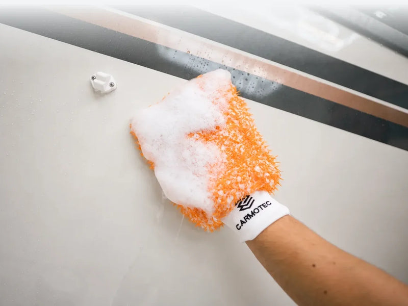 Carmotec Washandschoen wast de wand van een camper met veel sop