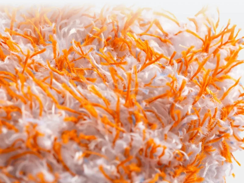 Close-up van de zachte oranje-witte vezels van de Carmotec Washandschoen